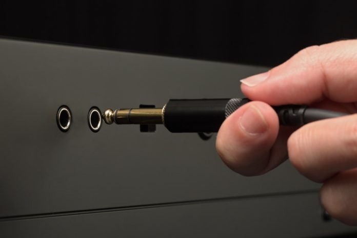 person-plugging-audio-cable-3531847