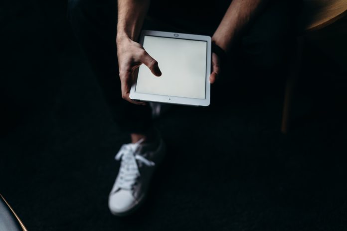 person-holding-white-tablet-computer-4065149