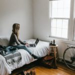 woman-in-gray-shirt-sitting-on-bed-3954635