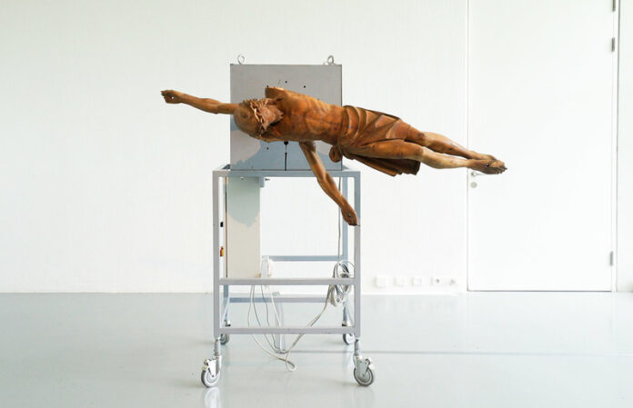 (c) Manfred Erjautz: Your Own Personal Jesus, 2012–16. Durch das Funksignal (DCF 77) des Langwellensenders in Mainflingen gesteuerte Turmuhr mit schleichender Sekunde; Christus-Corpus, geschnitzt, mit Bier getönt, Allgäu um 1880. (Ausstellungsansicht FO | Foto: Johannes Rauchenberger.